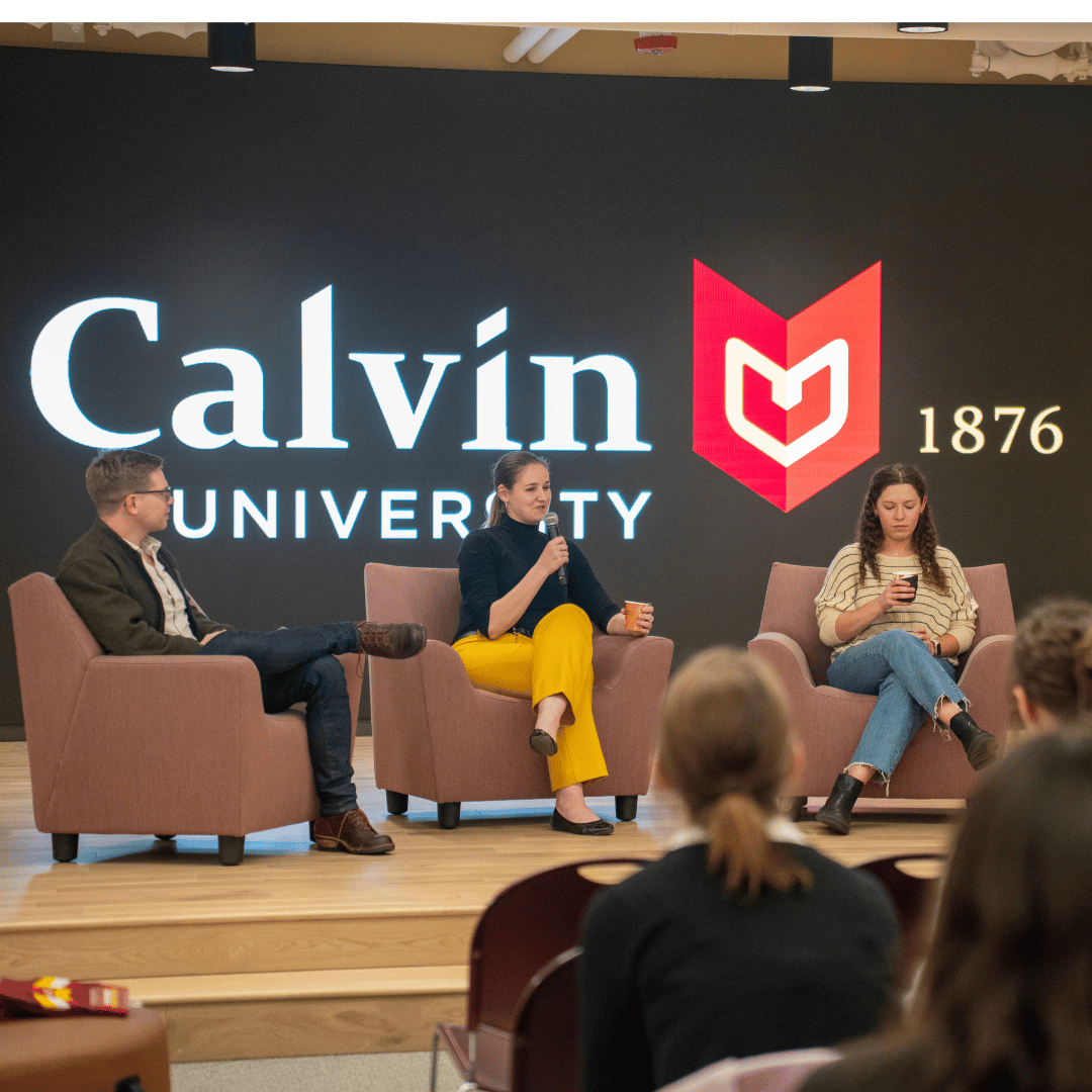 3 Calvin English Alumni sitting in chairs on stage. 