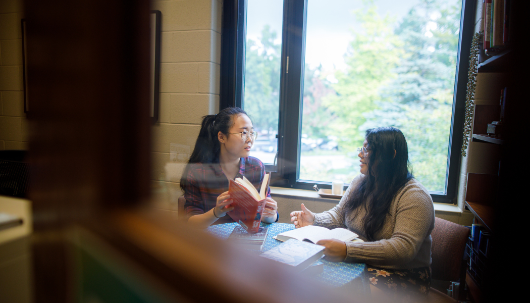 Two students sitting a table. 