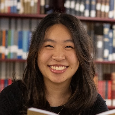Pauline Lu in front of a bookshelf in the Hekman Library.