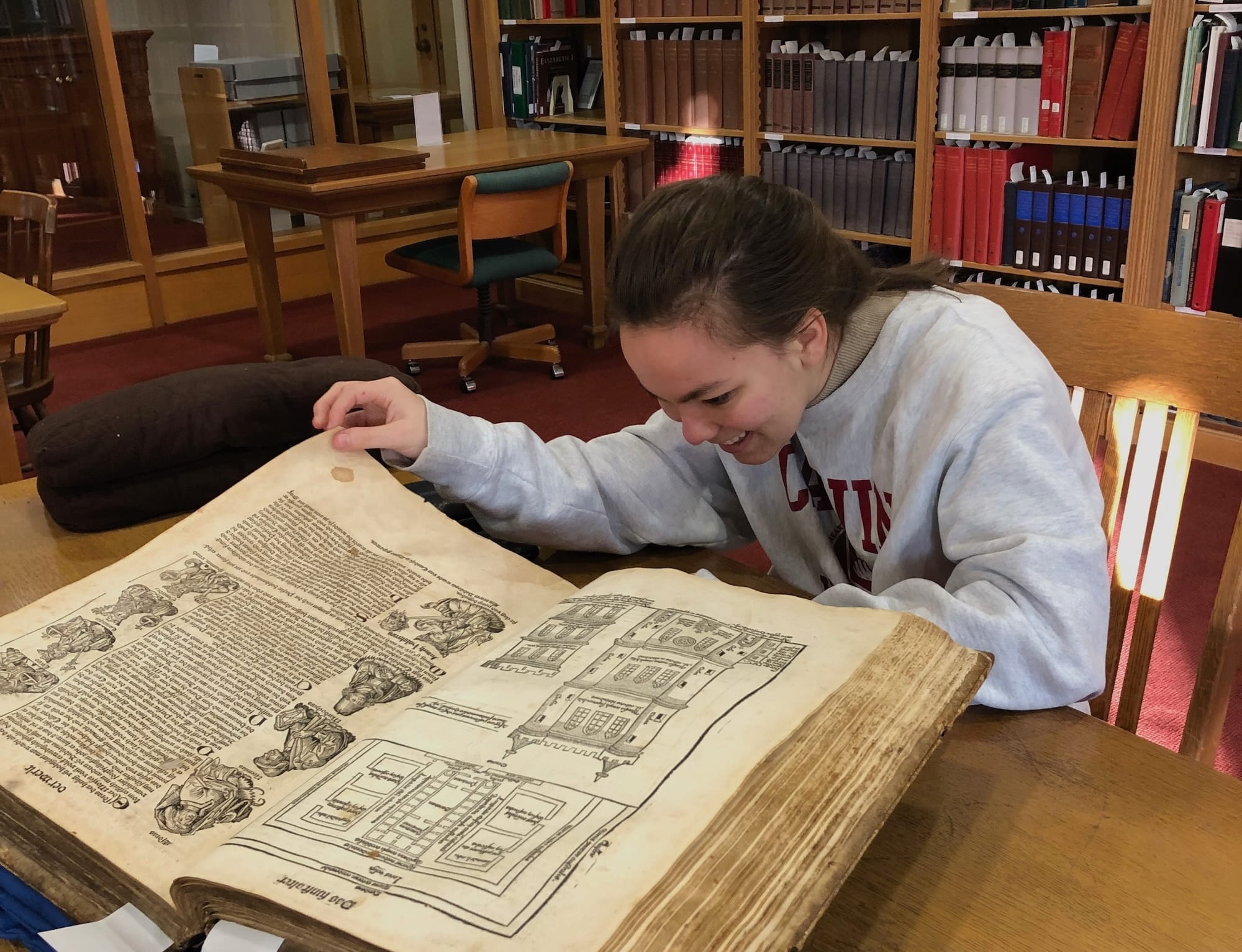 A student reads an old, large book.