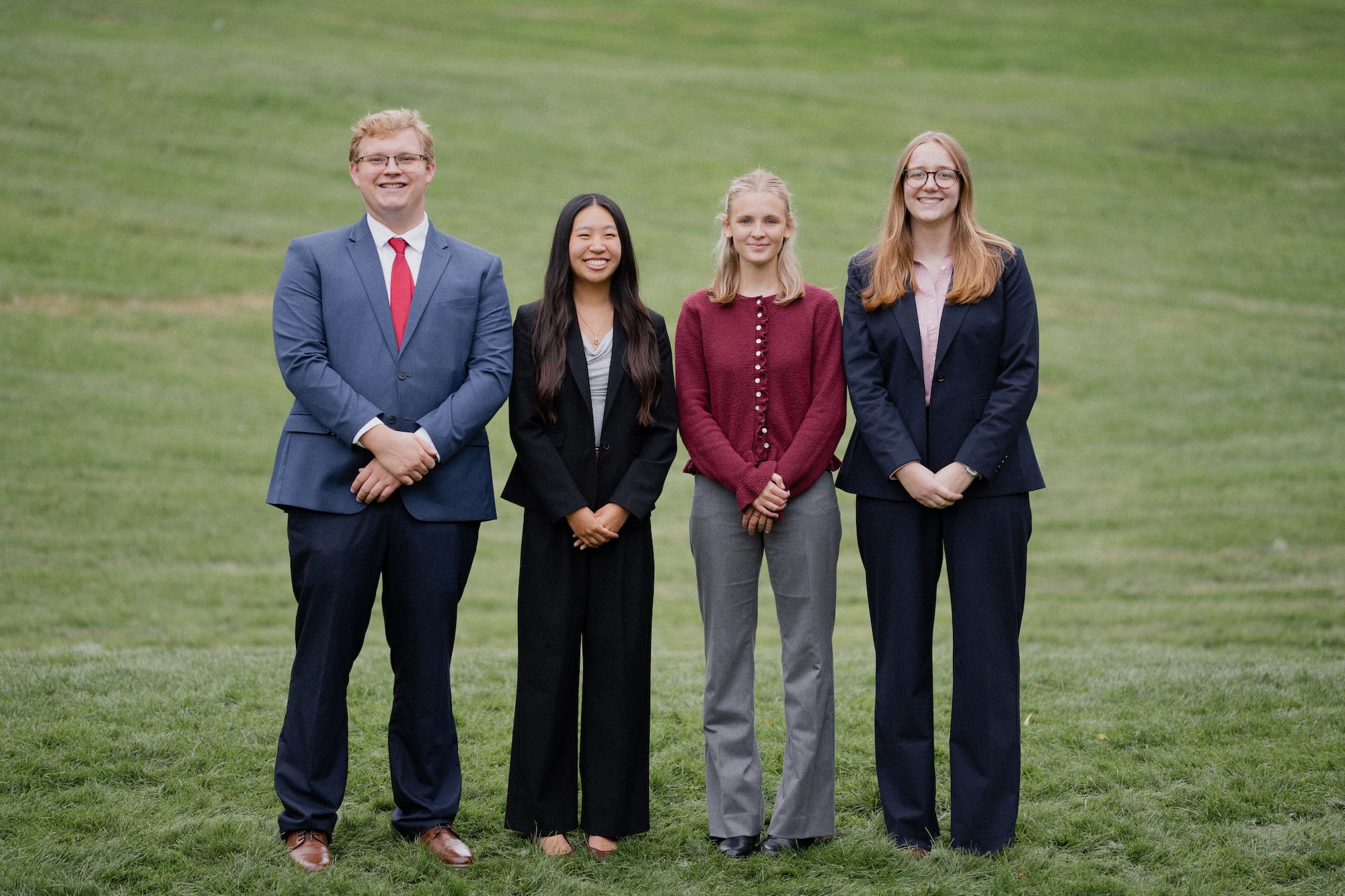 The four student senate cabinet members stand on the lawn at Calvin.