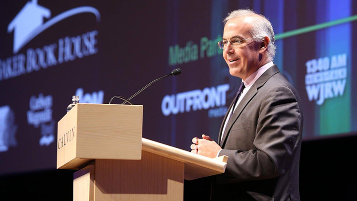 David Brooks delivers a lecture from behind a podium on a stage at Calvin University.