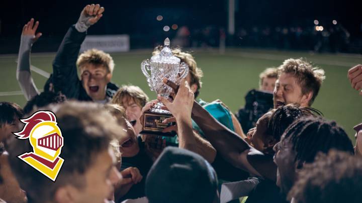 Soccer players holding a trophy over their heads