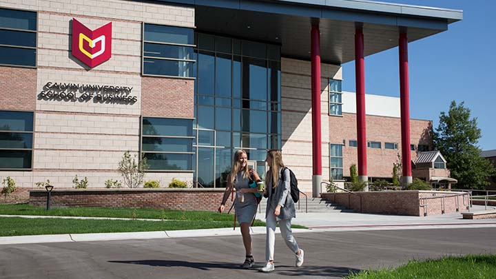 Two students walking outside of School of Business building on Calvin University's campus.