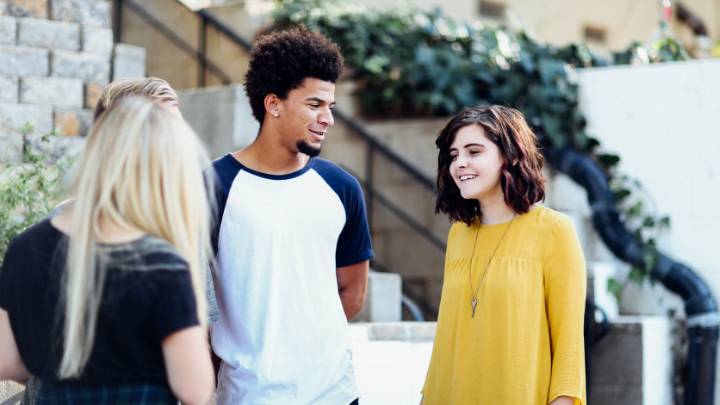 Two girls and a guy engage in conversation