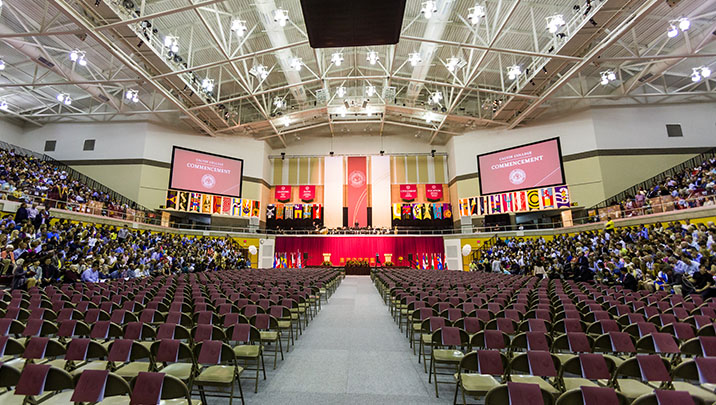 An arena full of people awaiting the graduates to process in for their graduation ceremony.