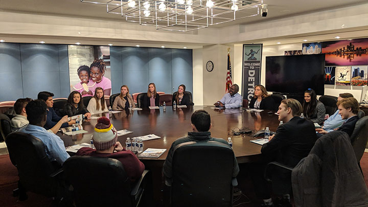 Students and city leaders meet around a roundtable.