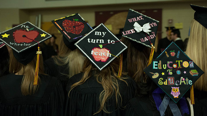 Graduation caps with writing on them like "Educated to Educate."