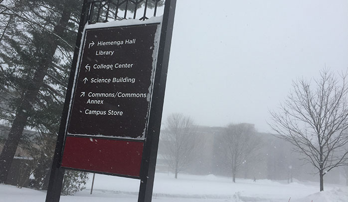 Calvin College sign with a wintery background.