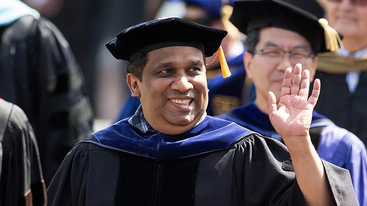 Kumar Sinniah walks in the faculty processional at Calvin University's 2021 Commencement ceremony held at LMCU Ballpark.