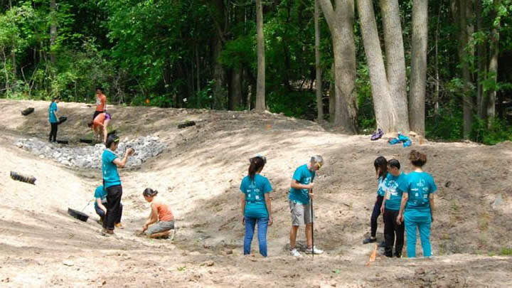 Volunteers work with the Plaster Creek Stewards to plant a bio-swale to capture stormwater