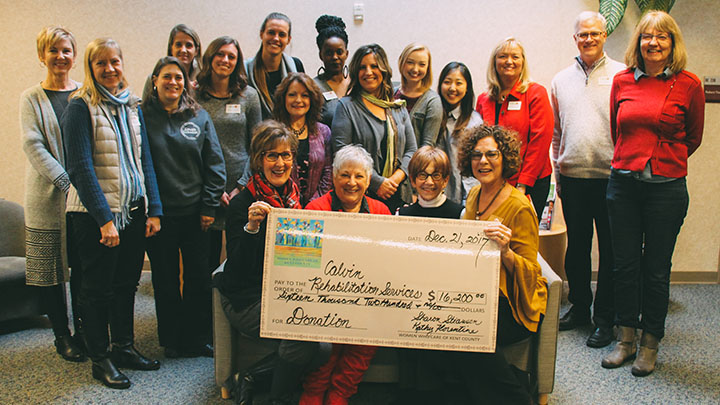 Jill Bates (front row, far right) is surrounded by CCRS staff, students and patients as she receives the $16,200 check from leaders of Women Who Care of Kent County.