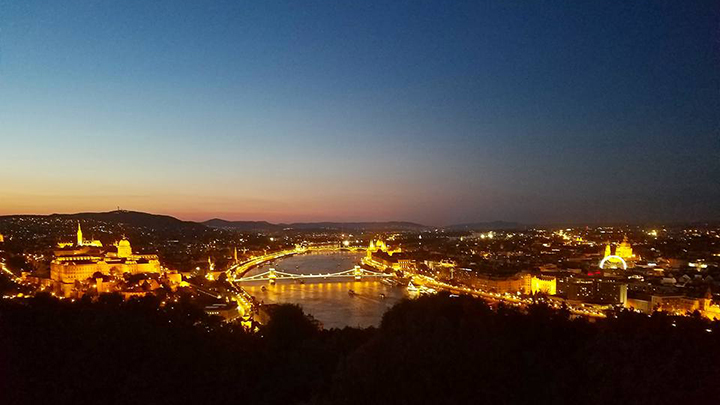 A cityscape at night of downtown Budapest, Hungary alongside the Danube River.