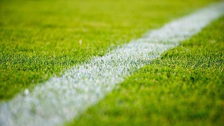 A football field's green turf and a white yard line.