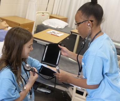 Girls practicing taking vitals  