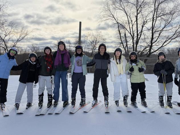 Calvin University students stand in a line with skis on