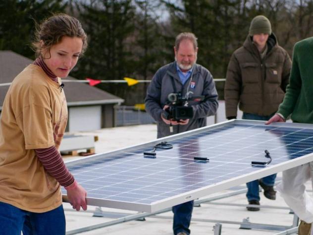Sofie Schumerth helps install solar panels on roof at Calvin University
