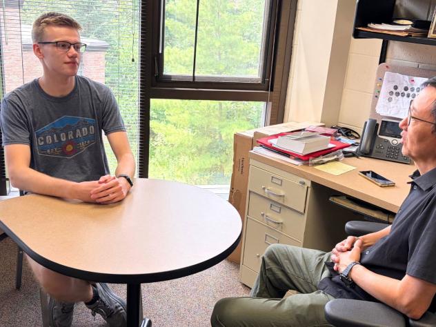 Landon Faber talks with Professor Rocky Chang in his office.