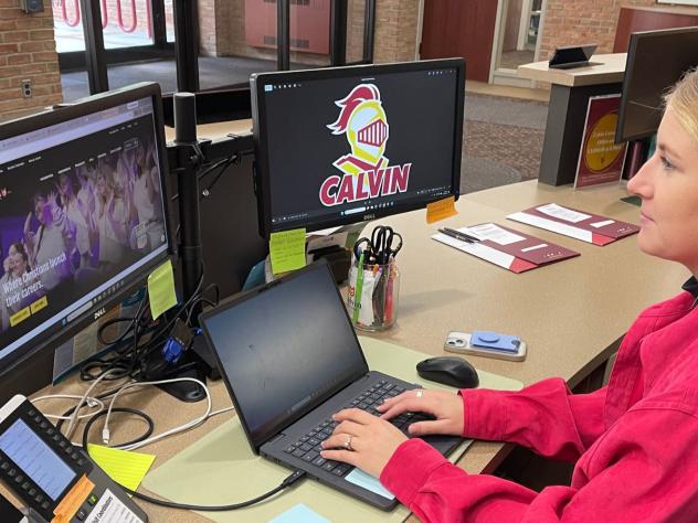 A staff member sitting at a desk typing on a computer