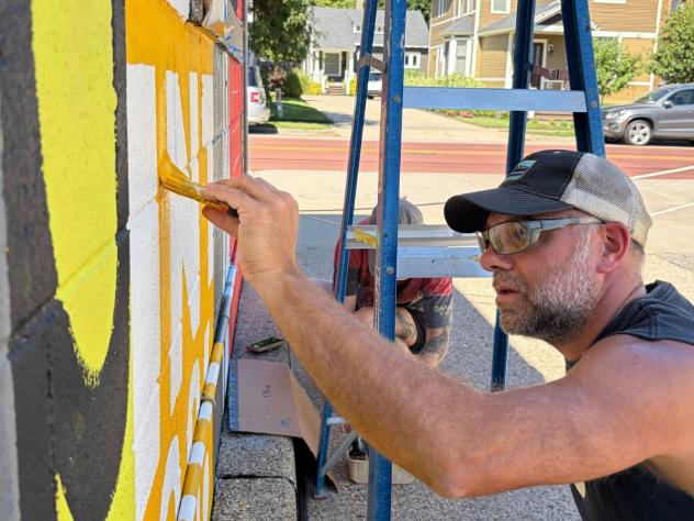 Chris Fox, professor of graphic design at Calvin University, painting a mural in Grand Rapids, Michigan.