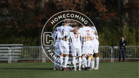 Male soccer players huddled together on field