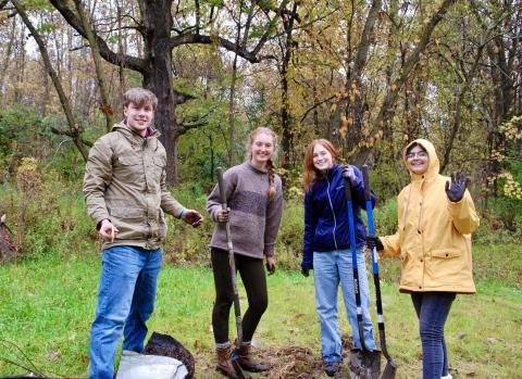 Calvin students planting a tree at the PCS Fall Event