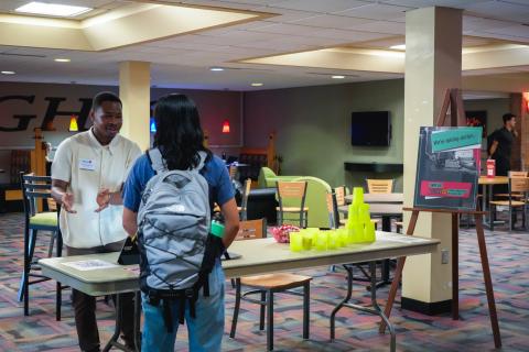 An image of a boy telling another student about swipe out hunger