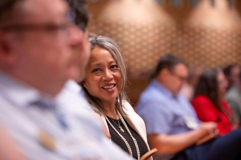 Woman looking at the camera in a room of others