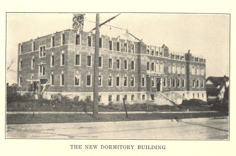 Historical photo of a three-story dorm building.