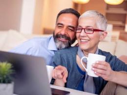 Adult male and female sitting in front of a laptop watching a webinar