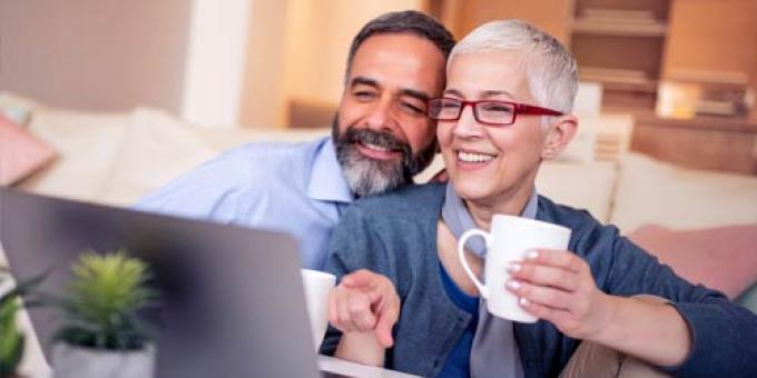 Adult male and female sitting in front of a laptop watching a webinar