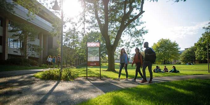 Calvin University students walking on campus with sunshine in the background