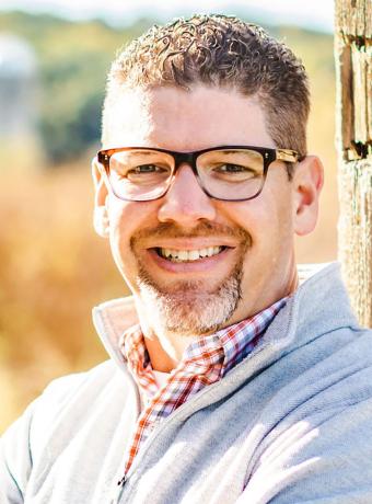 Luke Robinson smiling while posing for the camera on a sunny day.