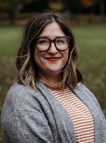 Photo of Lauren Cooper, smiling in front of grass background