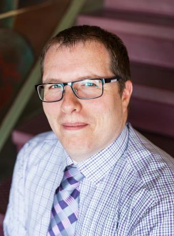 Robert Joustra headshot photo with red stairs in background