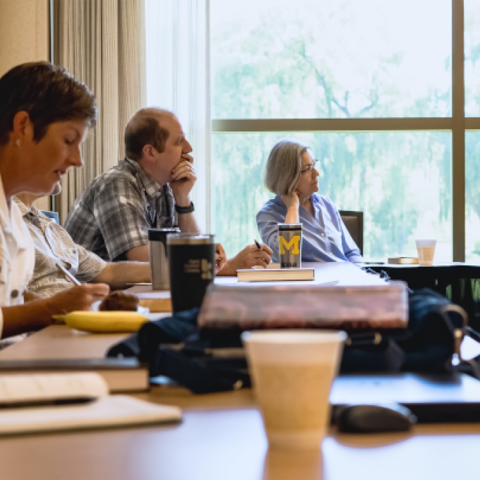 Calvin faculty members at a table listening in a conference