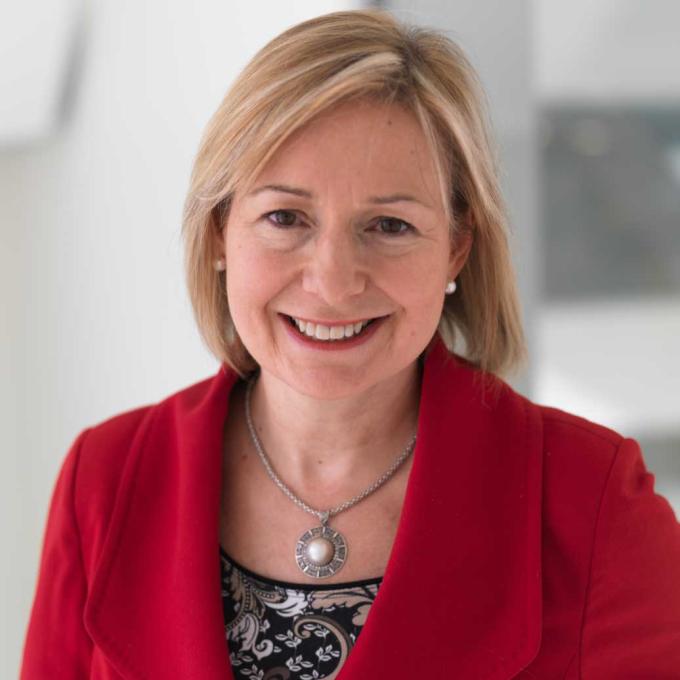 Rosalind Picard, smiling in a red blazer.