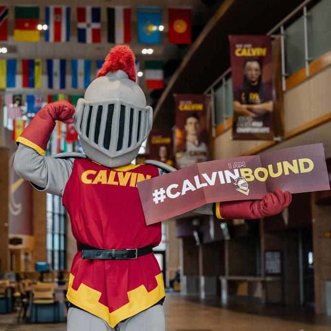 Joust flexing and hold a sign printed with #CALVINBOUND!
