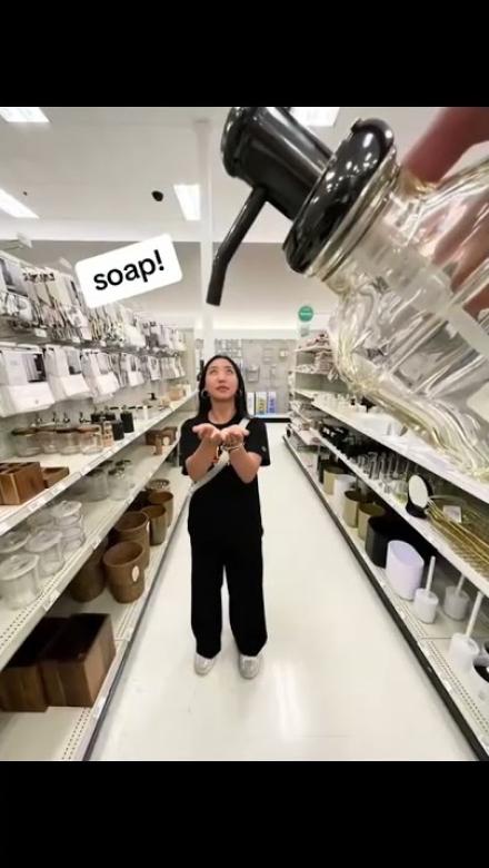 A calvin student in a store aisle with a soap bottle in the foreground dispensing into her hands in an optical illusion.