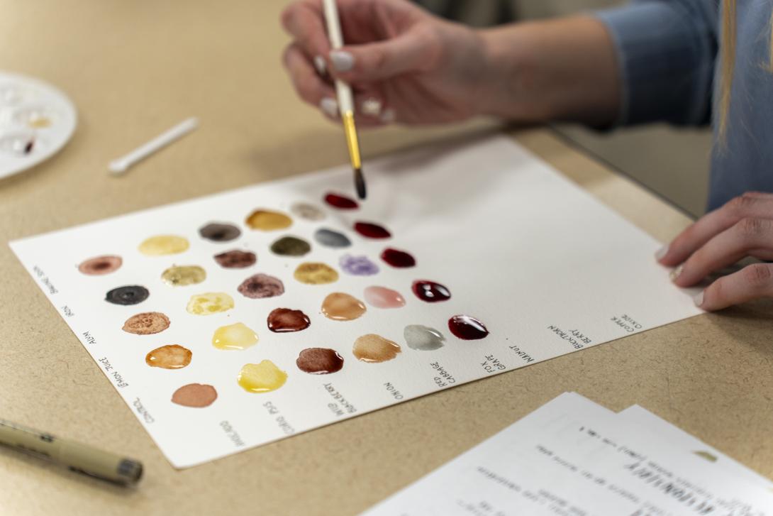 student painting with ink from plants