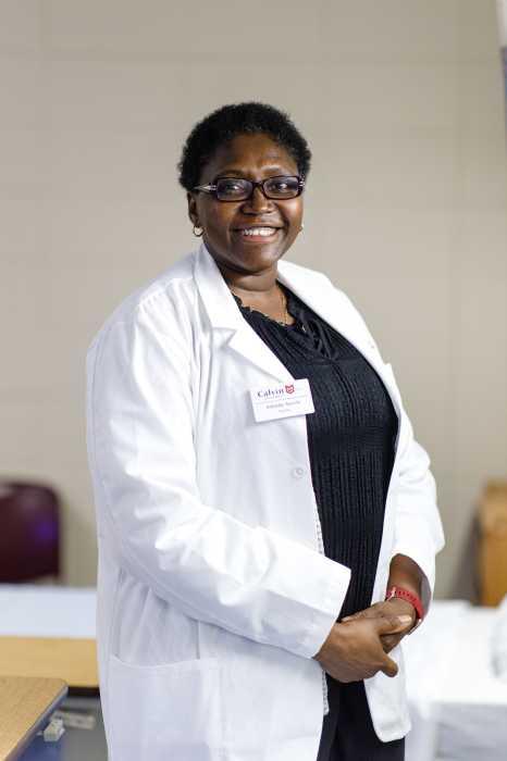 Dr. Ayoola in a white lab coat and Calvin nametag.