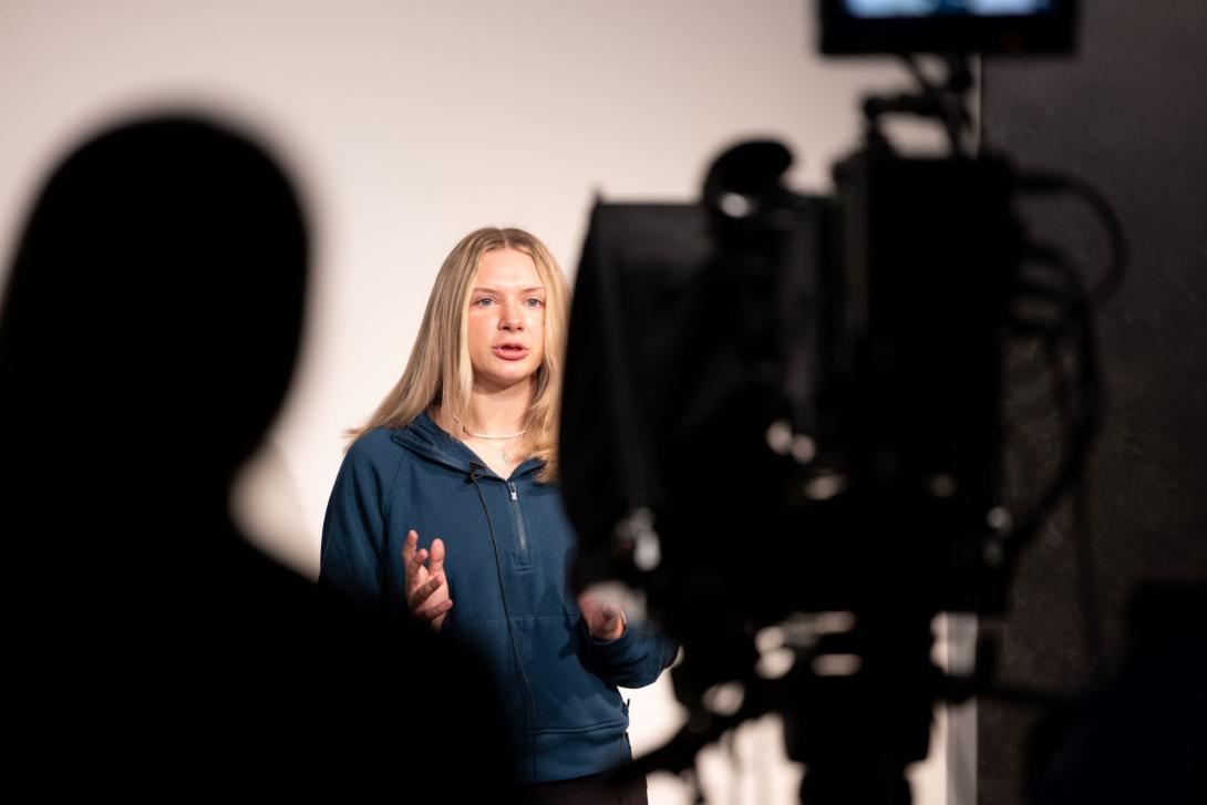 Woman speaking in front of a camera