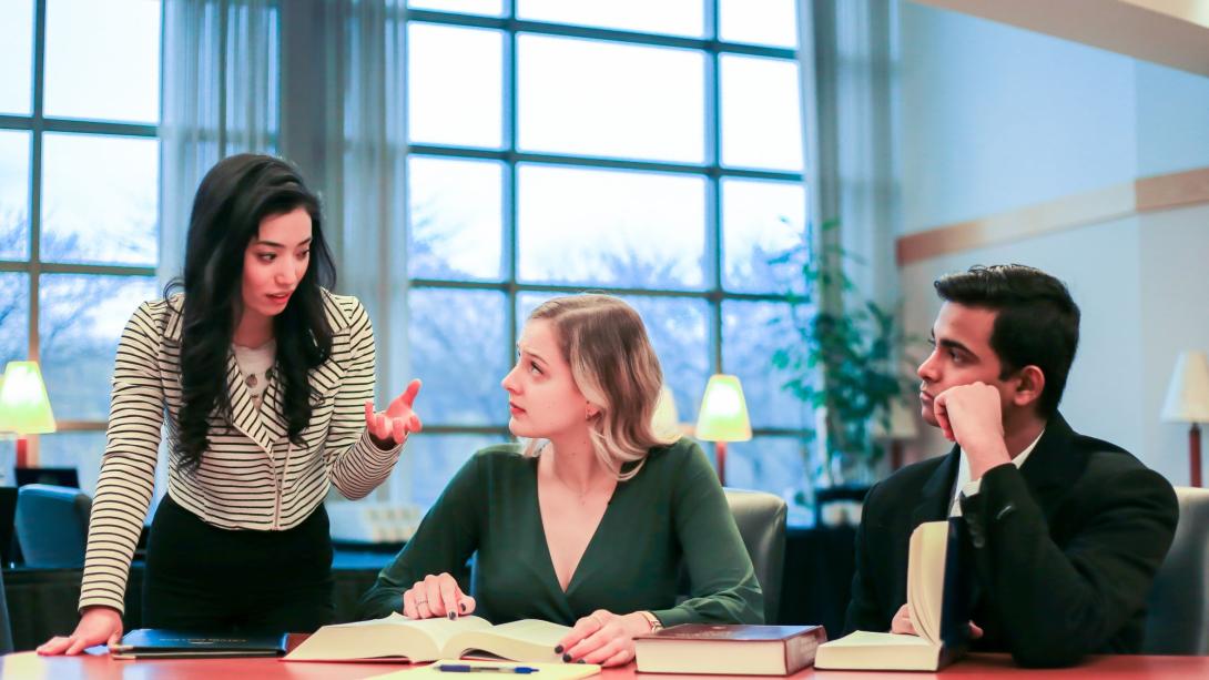 Three law students talking at a table