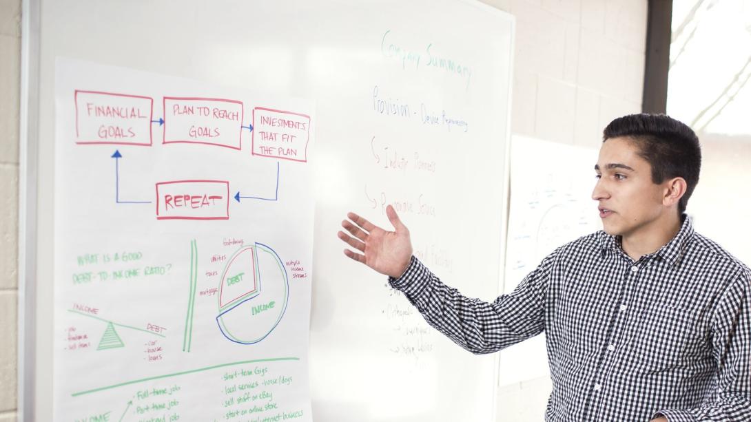 Student pointing at a whiteboard