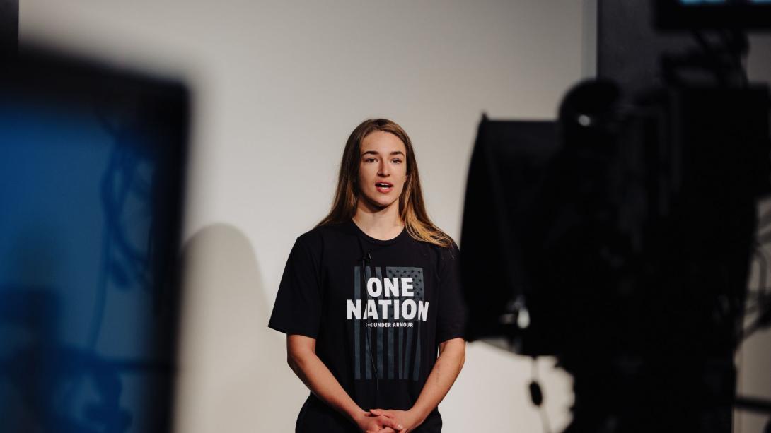 Woman speaking in front of a camera