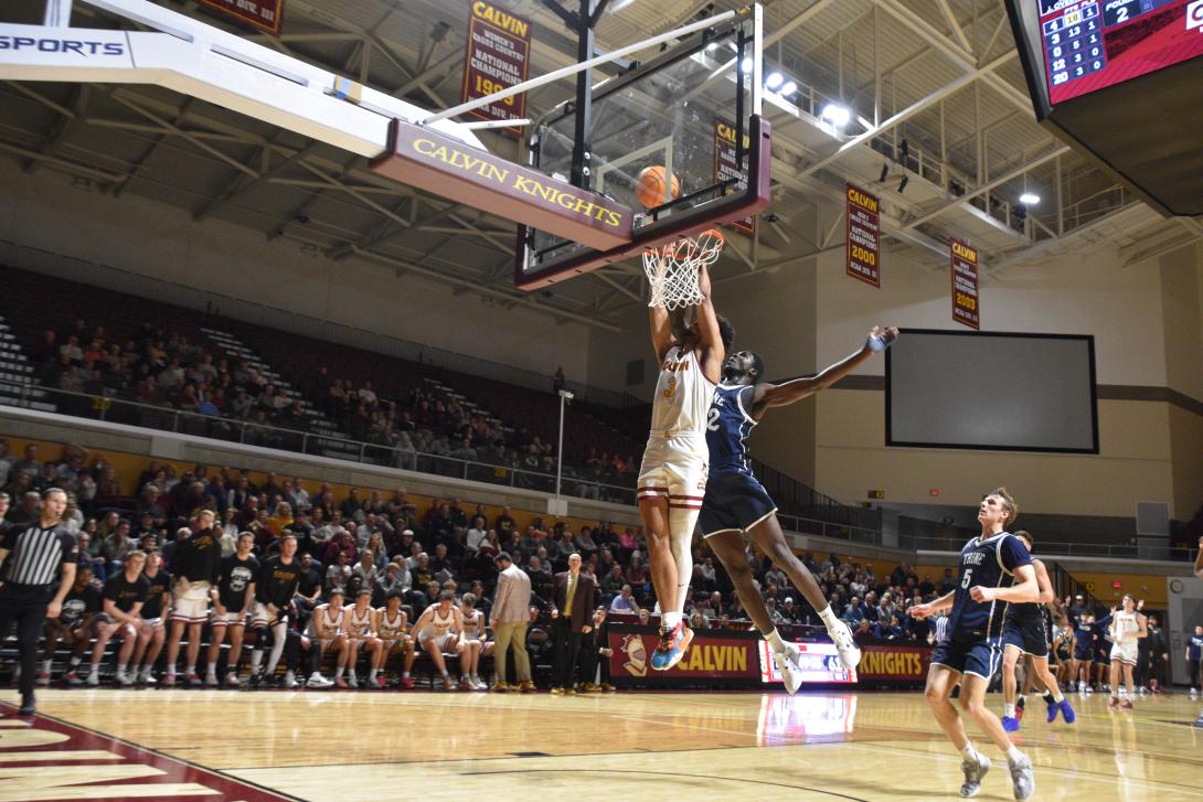 Calvin university men's basketball player about to dunk the basketball