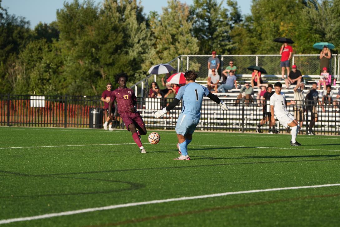 Calvin University men's soccer player about to kick the ball