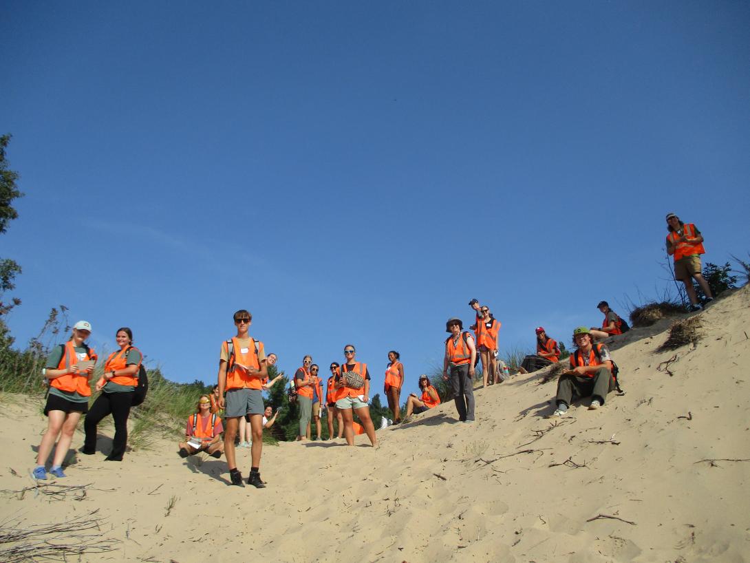 FYRES students gathered near top of dune under blue September sky.