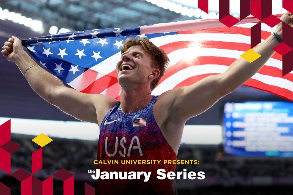 Hunter, a white man with sandy brown hair, wears a USA Olympic uniform and holds USA flag over his head, smiling. He is in a full arena that is blurred behind him.