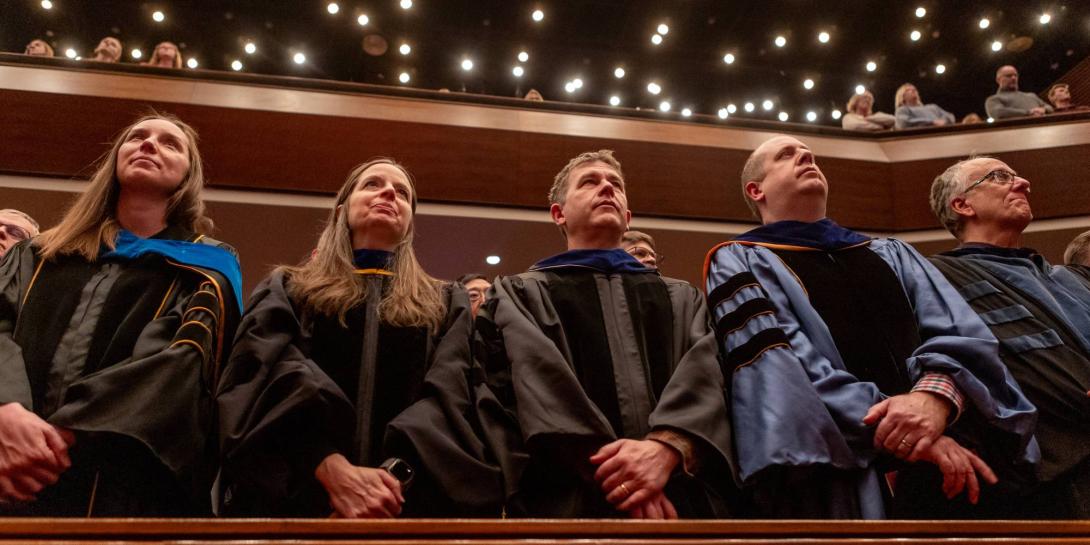 Calvin faculty stand in academic regalia in the Covenant Fine Arts Center auditorium